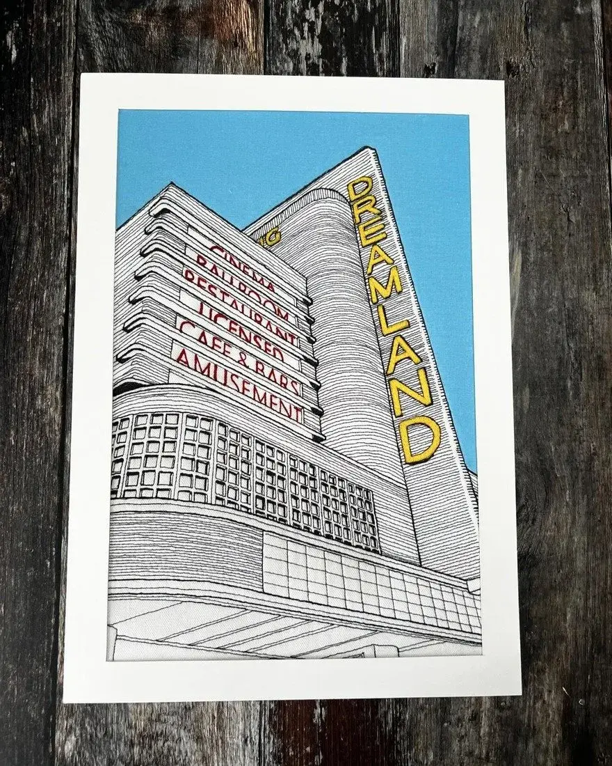 Broderie au fil de la façade art déco de Dreamland avec son enseigne verticale, sur fond bleu