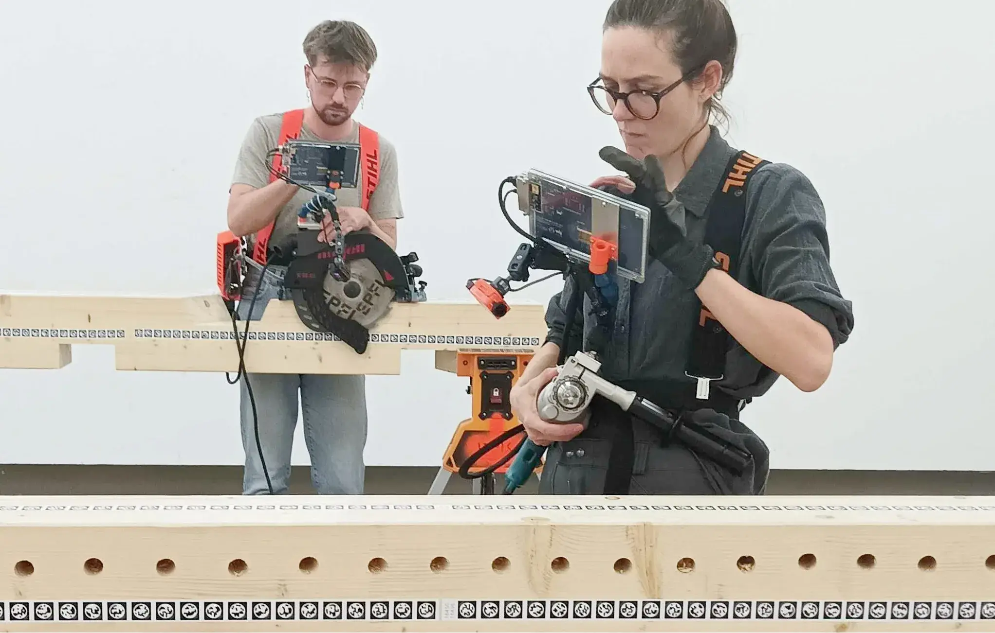 Deux utilisateurs testent Augmented Carpentry avec une scie et une perceuse guidées par écran
