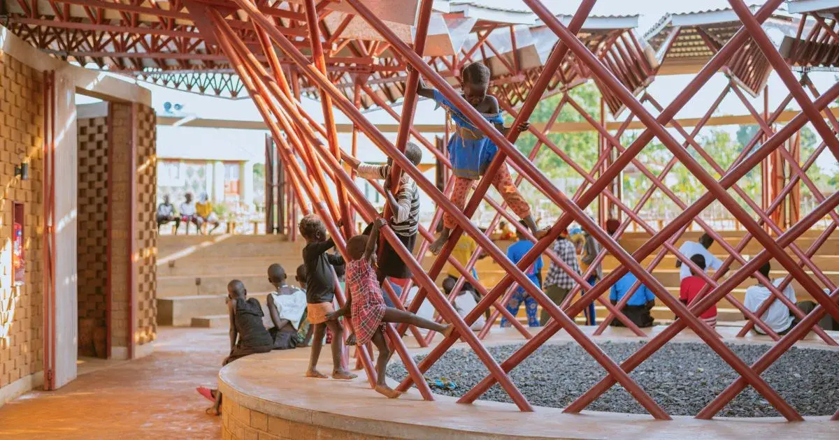 Centre des arts du spectacle Bidi Bidi en Ouganda, avec son large toit métallique au-dessus des murs en terre