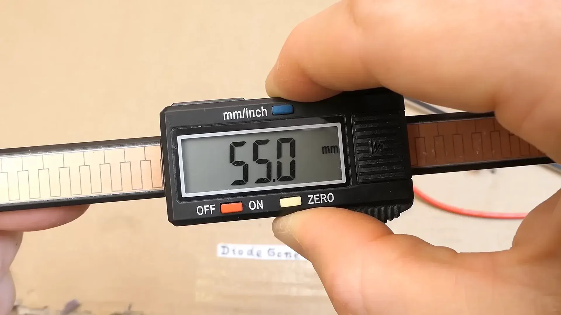Inside of a cheap digital caliper, showing the copper strip and electronics