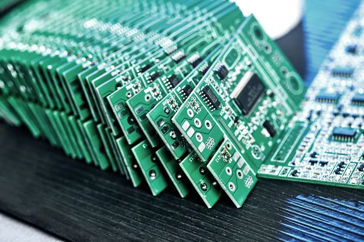 Cartes électroniques vertes empilées avec leurs composants, posées sur un plan de travail