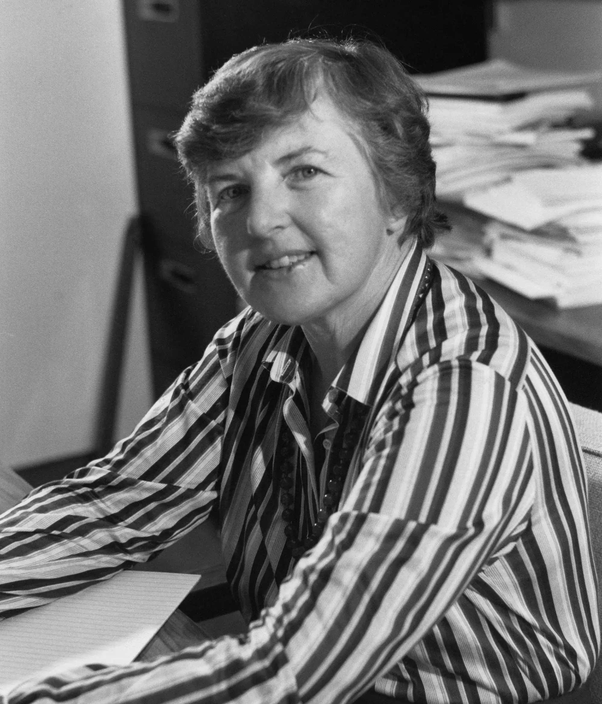Portrait noir et blanc de Frances Allen à son bureau, chemise rayée