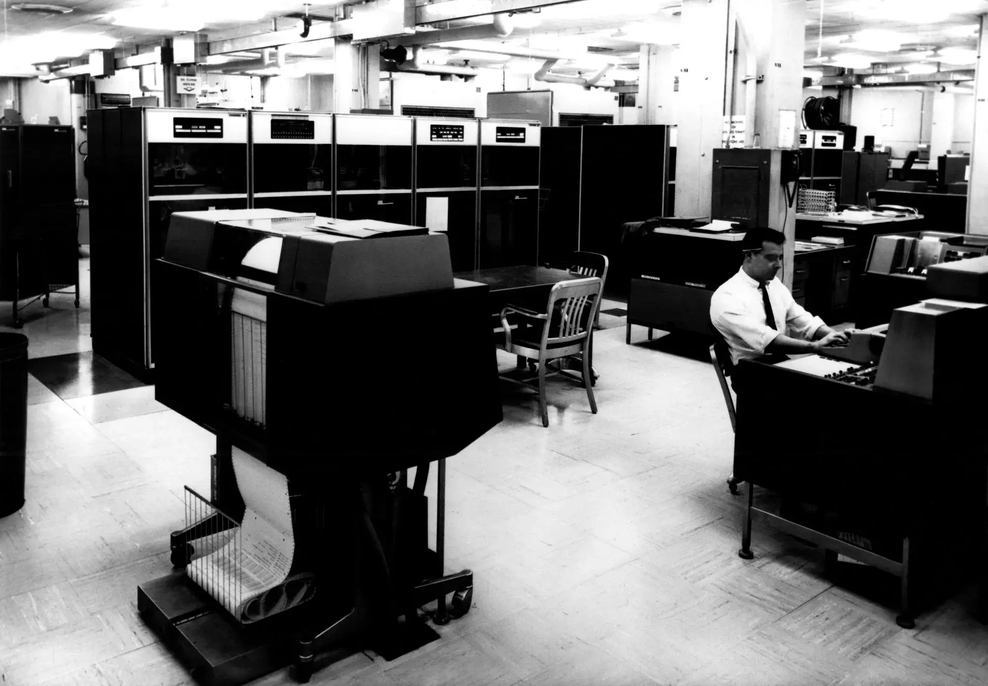 Salle informatique de la NSA à Fort Meade avec imprimantes et grands meubles d'ordinateur