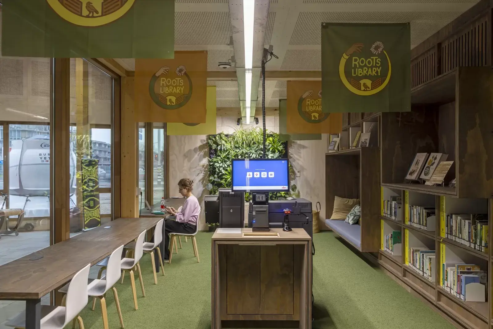 Espace intérieur de la Roots Library dans l'OBA Next Lab, avec mobilier et structure bois